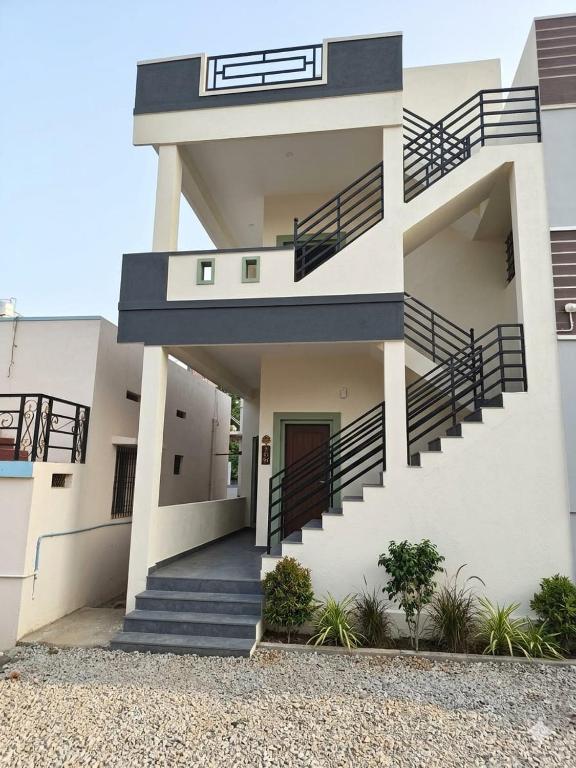 a white house with stairs and a door at VIDYA Homestay in Hampi