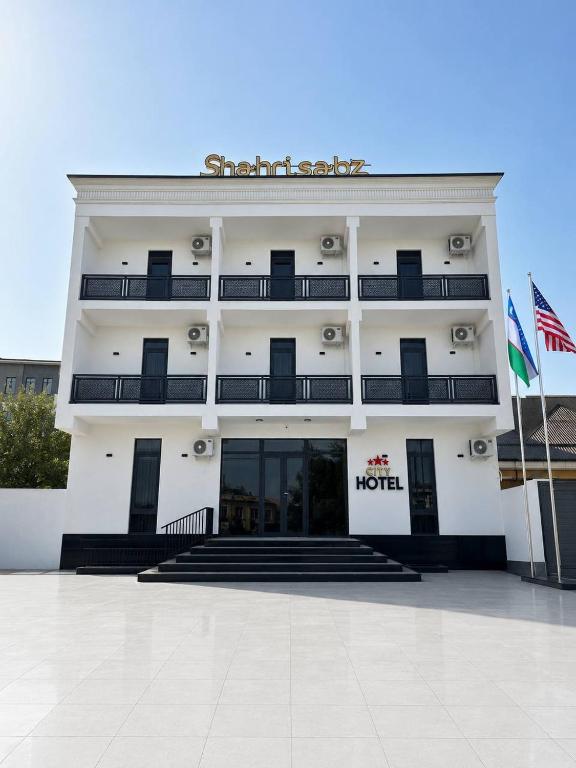 a hotel with a sign on the front of it at shahrisabz city hotel in Shahrisabz