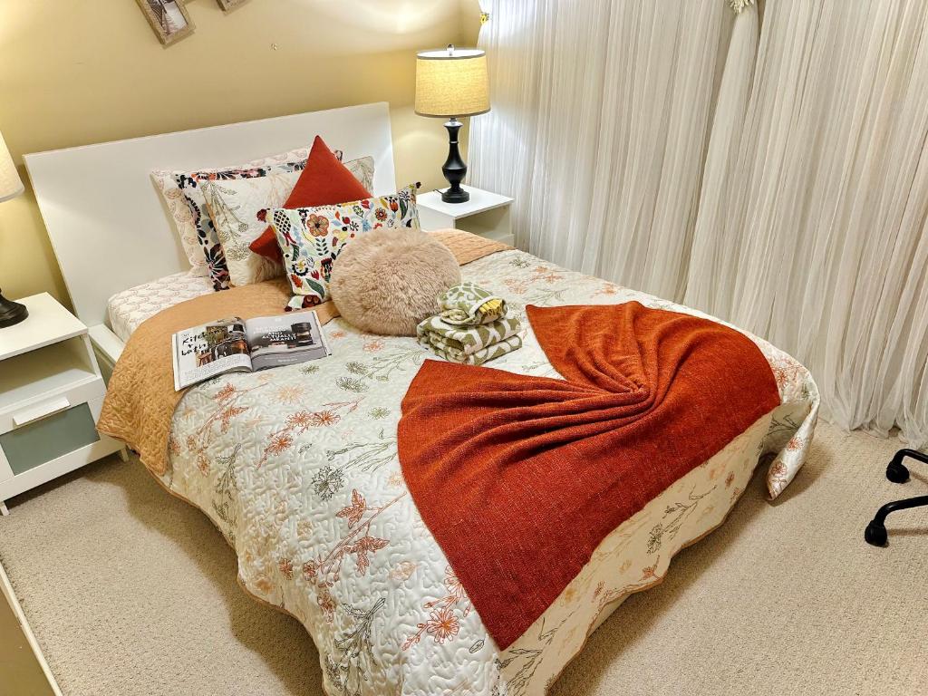 a bedroom with a bed with a blanket on it at Scorpio House Langley - Semi-basement Suite in Langley