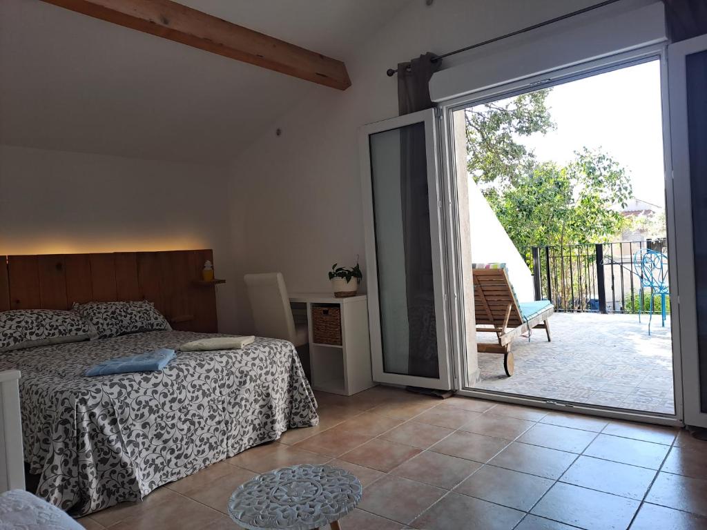 a bedroom with a bed and a sliding glass door at BEAU STUDIO NEUF en provence in Pélissanne