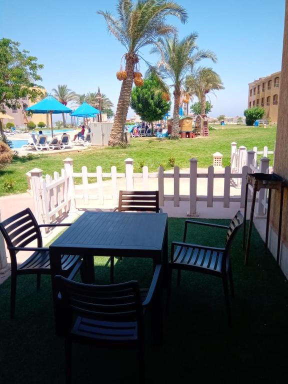 a table and chairs with a fence and palm trees at ساوث بيتش بورتو السخنه in Ain Sokhna