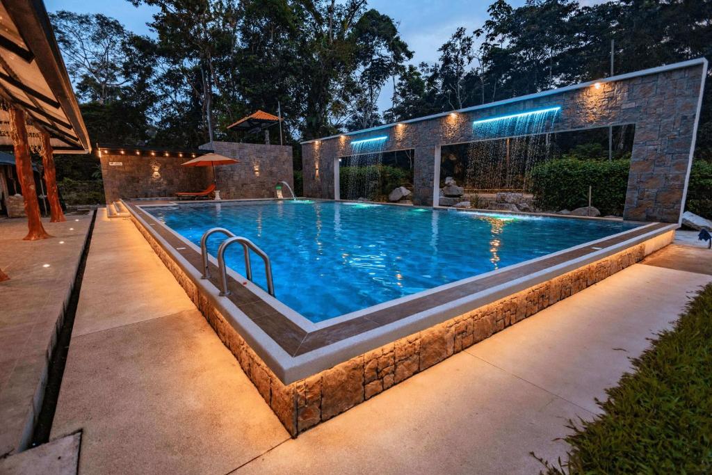 a swimming pool with lights in a backyard at night at QUINTA PRIMAVERA - Hostería Campestre in Nueva Loja