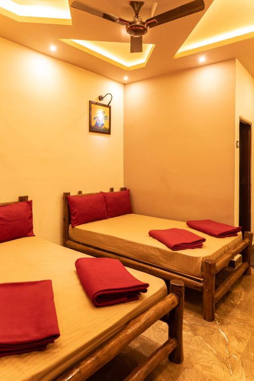 two beds in a room with red pillows on them at Green View Resorts in Munnar
