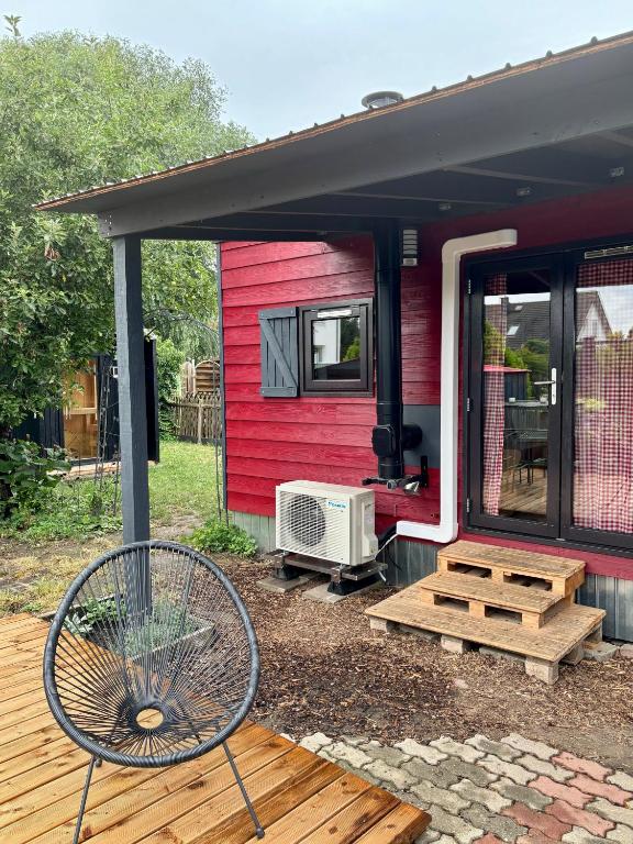 a red house with a deck and a chair at Chalet Josef in Braunsbedra