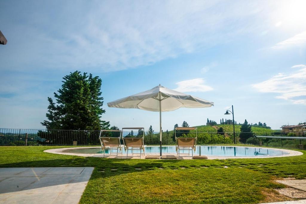 a table and chairs under an umbrella next to a pool at Entire house for couple with exclusive pool in Monsanto