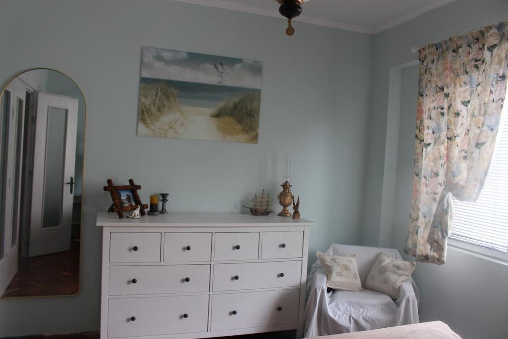 a white bedroom with a dresser and a mirror at Saltywind House in Pomorie