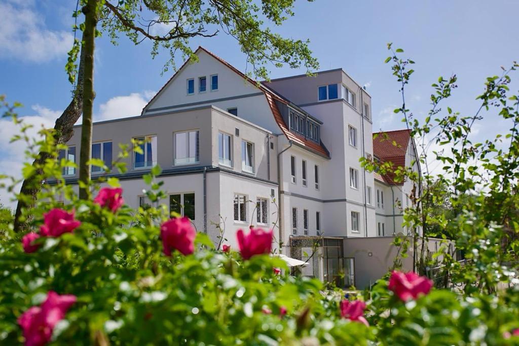 a large white house with pink roses in front of it at Haus Meeresstern in Wangerooge