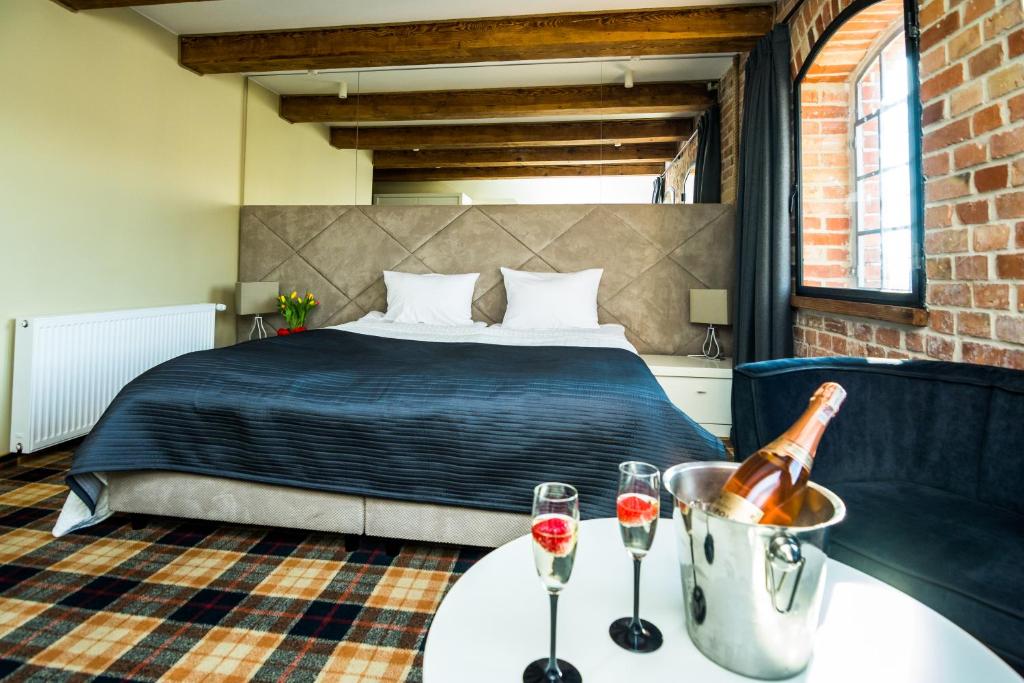 a bedroom with a bed and two wine glasses on a table at Armada Apart Ustka in Ustka