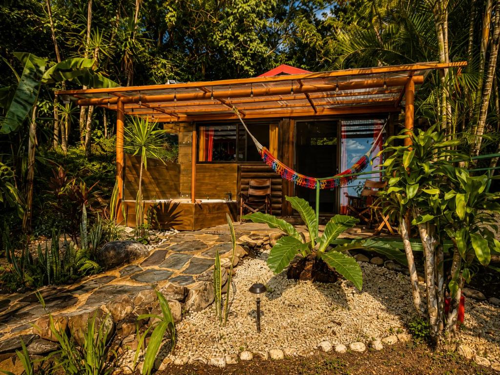 a small cabin in the woods with a stone walkway at El Sol Monteverde in Monteverde Costa Rica