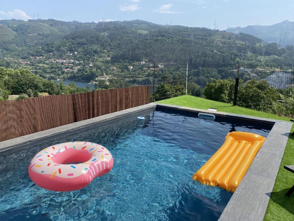 a swimming pool with a donut and a raft and a float at Relax House - Casa Castor in Valdosende