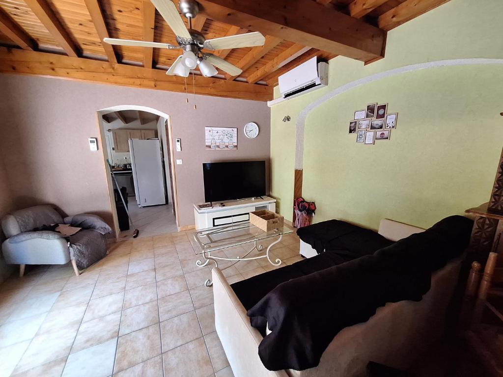 a living room with a couch and a ceiling fan at Gite de la véore in Chabeuil