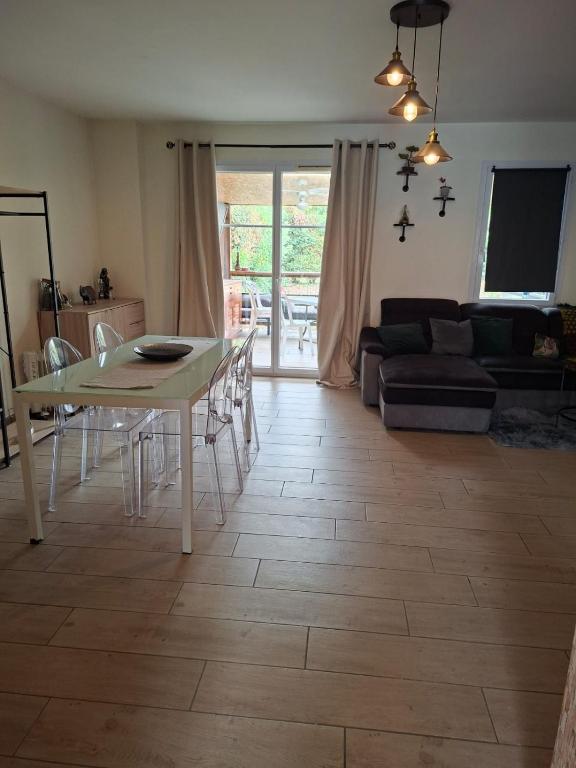 a living room with a table and a couch at Résidence Le Soleil de Nousty in Nousty