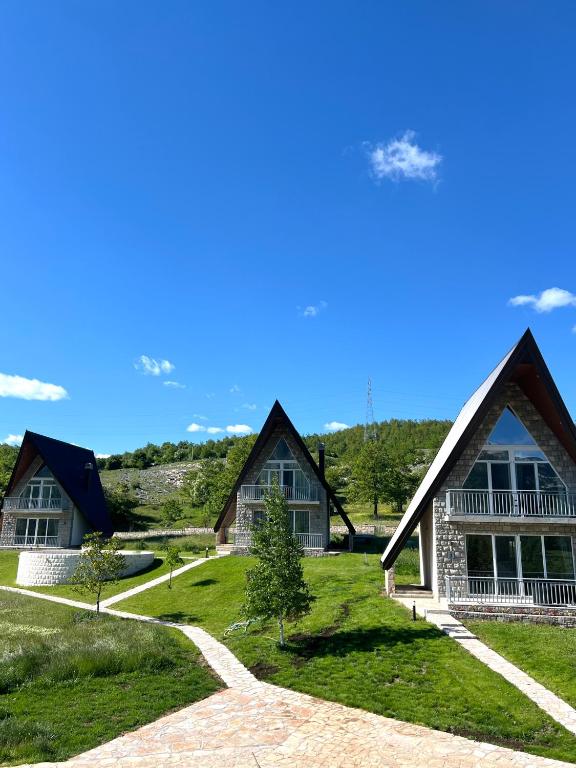 a group of houses on a grassy field at Monte Escape Village in Šavnik
