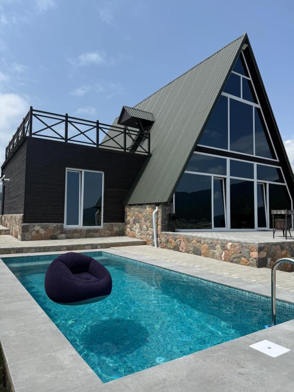 a house with a swimming pool and a building at SkyHouse Shahdag in Əniq