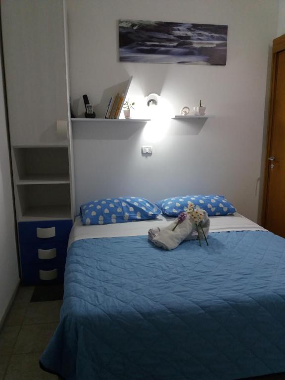 1 dormitorio con 1 cama con edredón azul en Casa Delle Rose, en Porto Cesareo