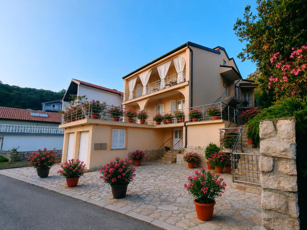 a building with flower pots in front of it at Apartmani Filip i Jakov in Senj