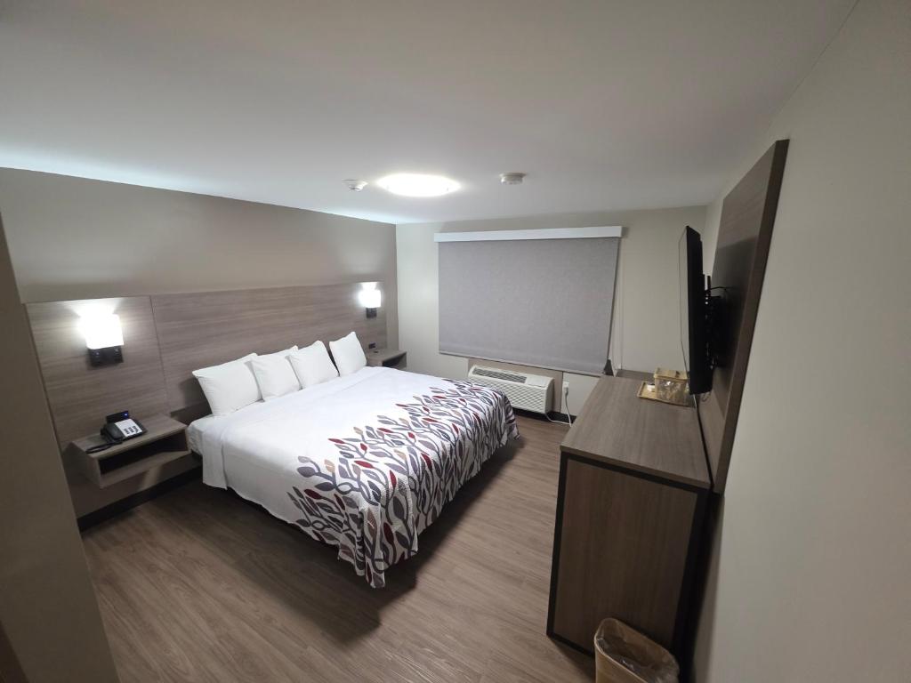 a hotel room with a bed and a projection screen at Red Roof Inn Sutton in Sutton