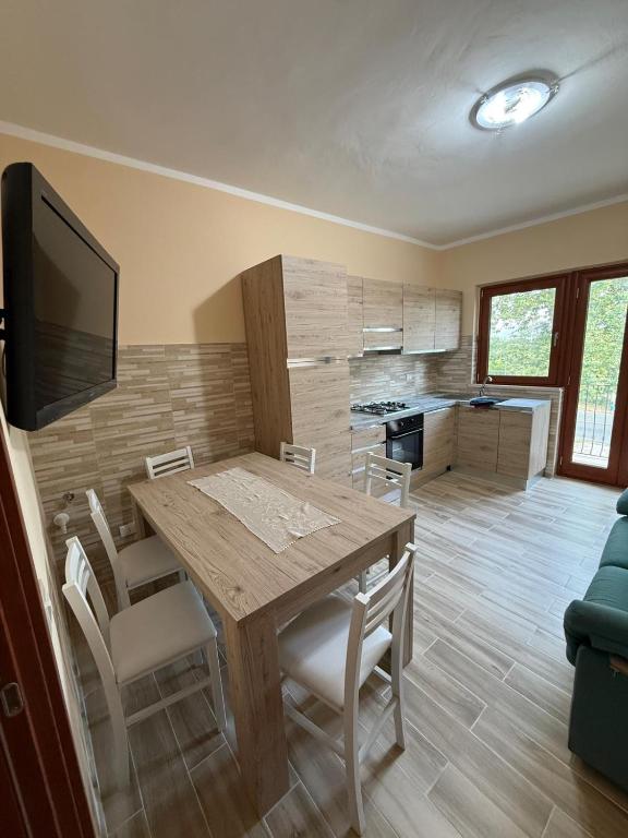 a kitchen and dining room with a wooden table and chairs at Vale house in Monte San Biagio