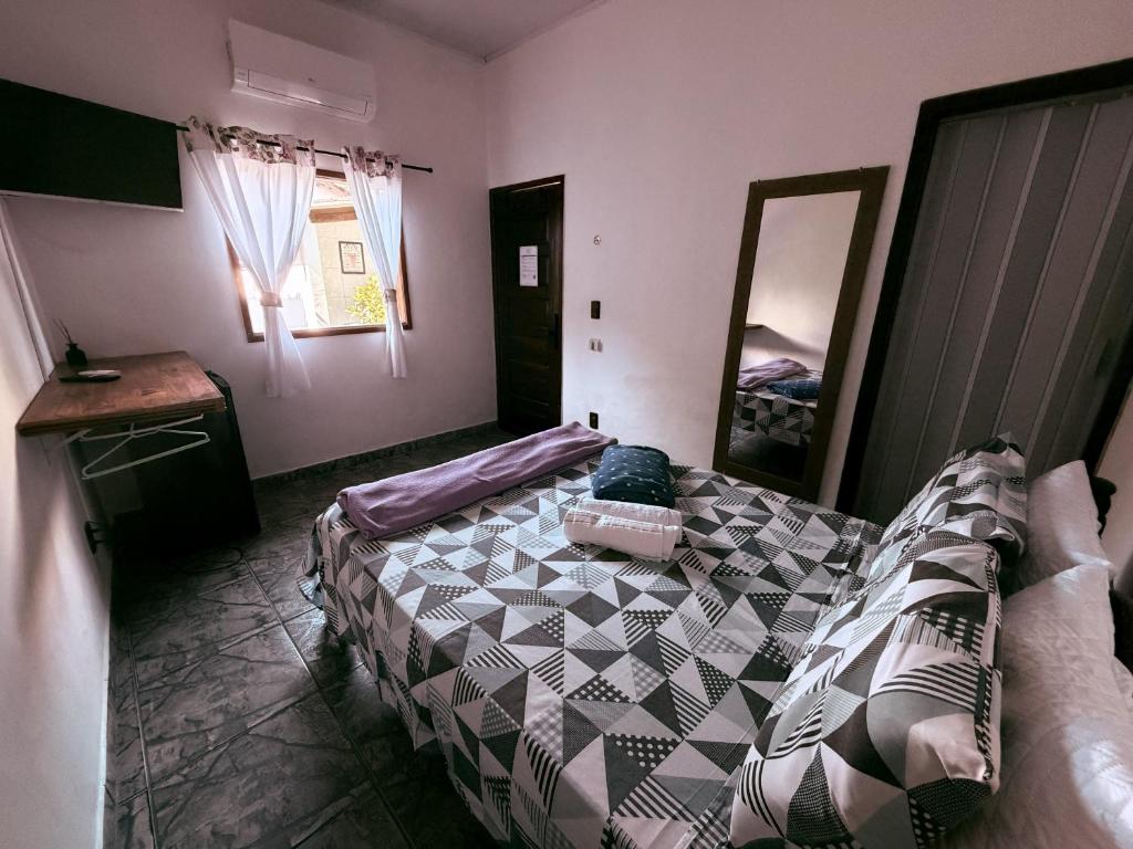 a bedroom with a bed and a mirror in it at Villavera - Caragua Centro in Caraguatatuba