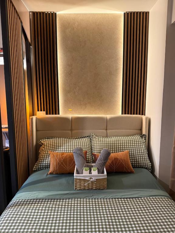 a bedroom with a bed with a headboard and pillows at Modern Japandi Studio with Pool Near Mactan Airport in Bankal