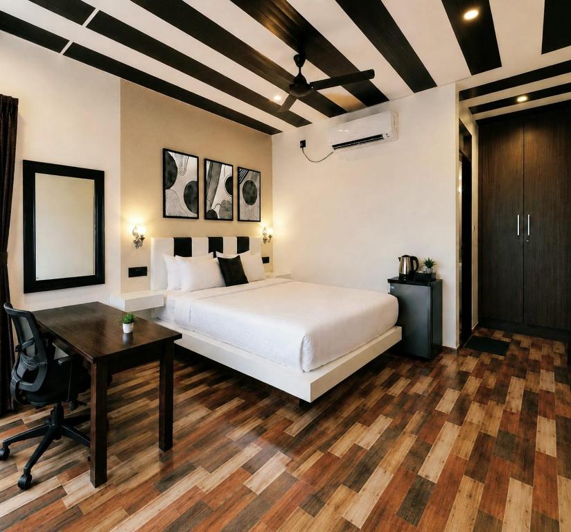 a bedroom with a bed and a desk and a table at Coco Nest Mandrem in Mandrem