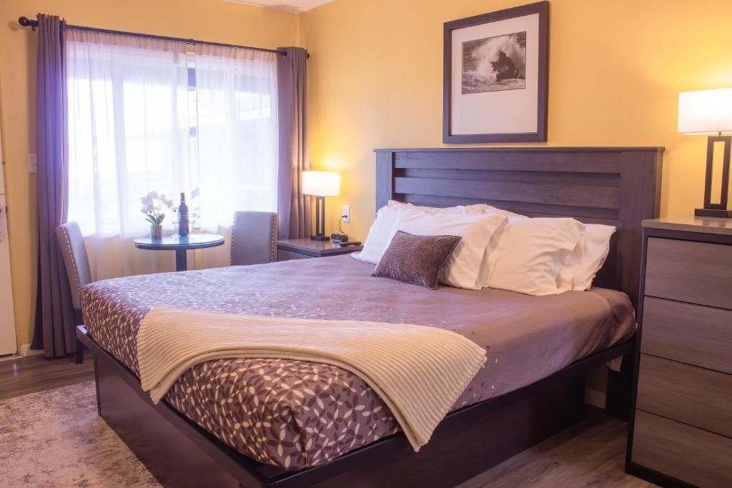 a bedroom with a large bed and a window at Carmel Wayfarer Inn in Carmel