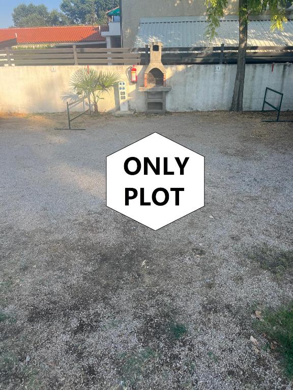 a sign that says only plot in a yard at Camp Mali Baška in Baška