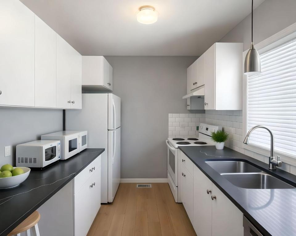 a white kitchen with white cabinets and a sink at PRAIRIE SKY GETAWAY in Cheyenne