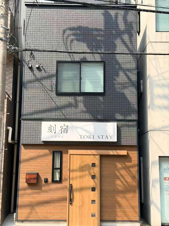 a building with a wooden door and a sign on it at 刻宿Toki Stay Ueno in Tokyo