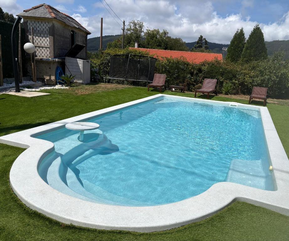 a swimming pool in a yard with a house at Casa con piscina in Cedeira