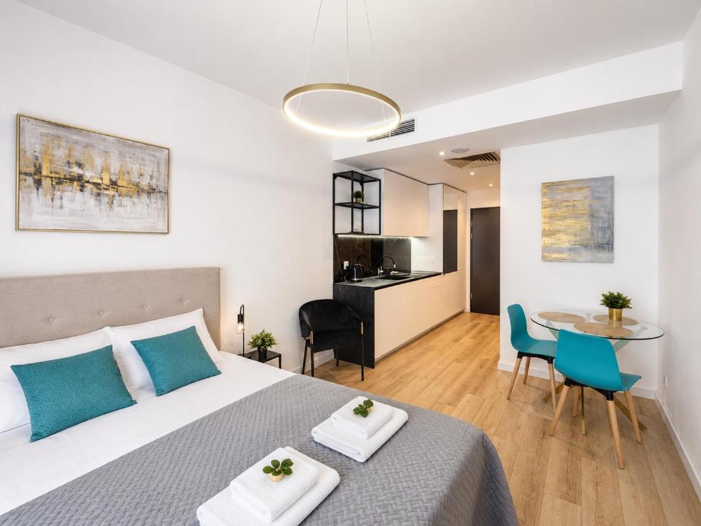 a bedroom with a bed and a table with chairs at Poznań Plac Wolności 6 Bond in Poznań