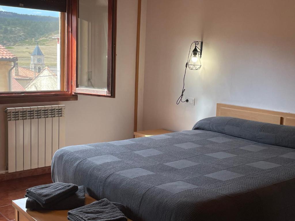 a bedroom with a bed and a window at Apartamento Uno in Guadalaviar