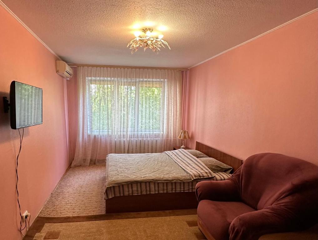 a small bedroom with a bed and a window at Nice Apartment in Kyiv