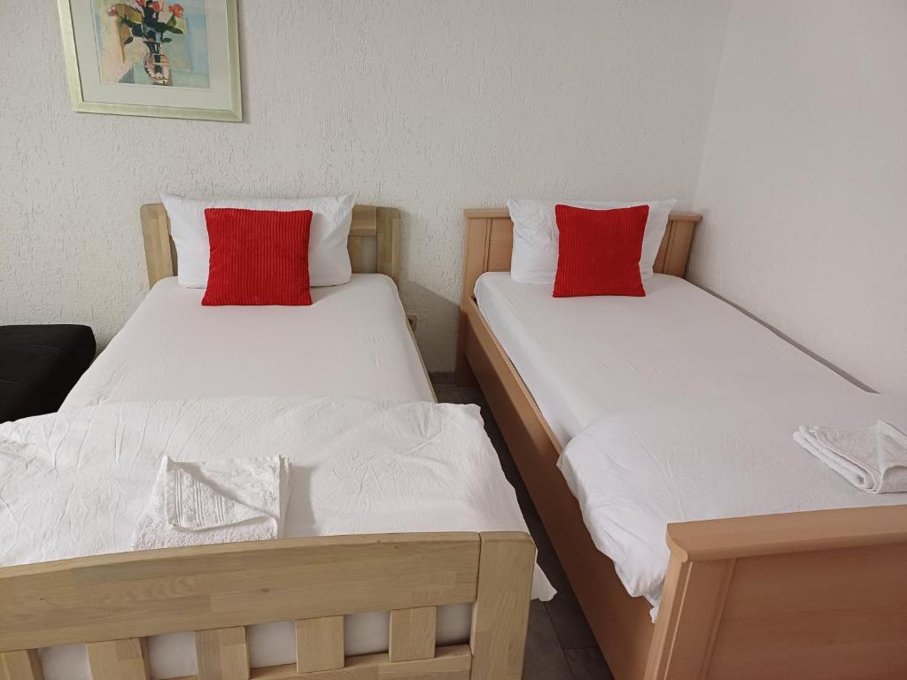 two beds in a room with white and red pillows at Guest house in Datteln 2 in Datteln