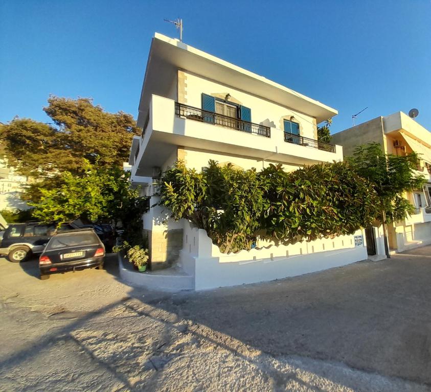 a white building with a balcony on the side of it at Studios Eftichia in Fournoi