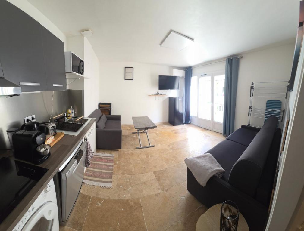 a living room with a couch and a kitchen at Le sunset in Bandol
