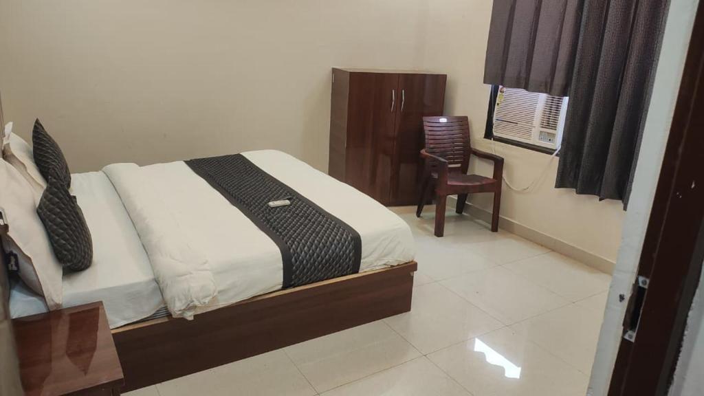 a bedroom with a bed and a chair in it at Hotel Grand Taj Pride in Tājganj