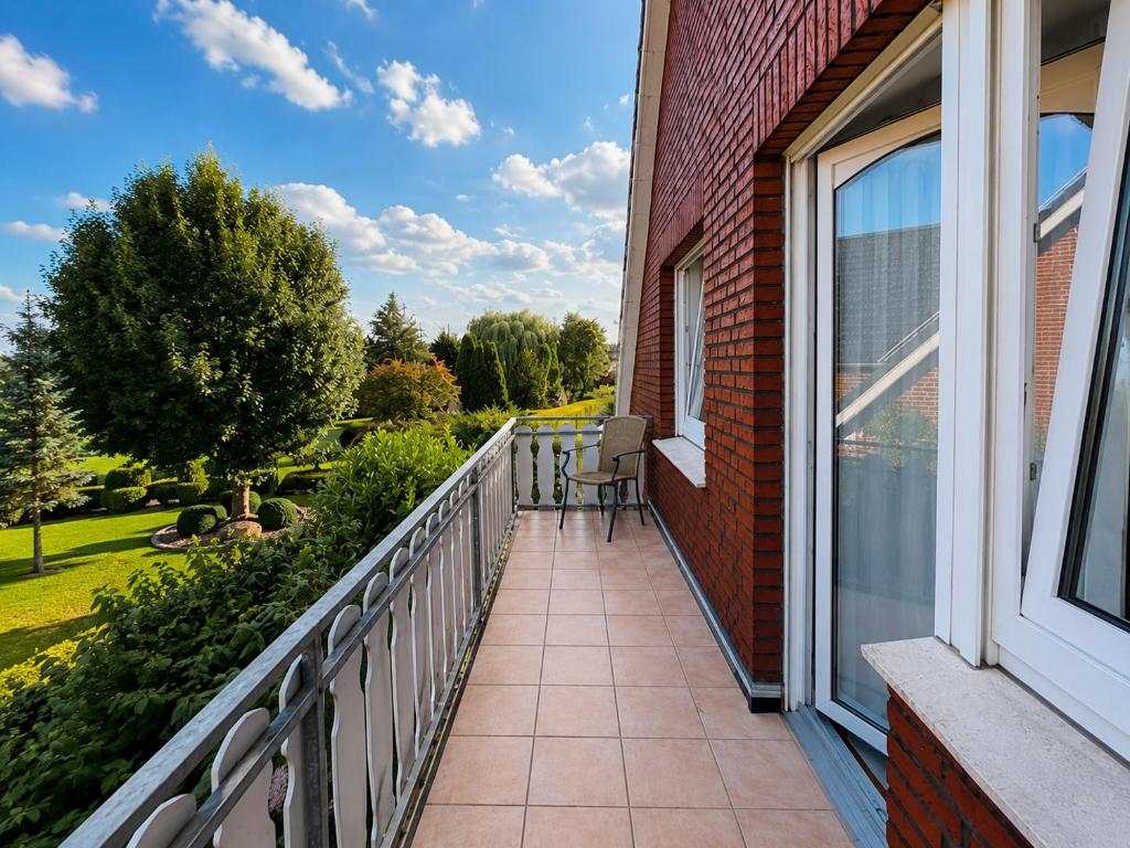 a balcony of a house with a chair on it at Lenyanca Apartment in Salzbergen