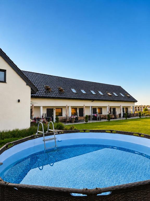 a swimming pool in front of a house at Sunrise Marina Domki Mielno- Ferienhaus in Mielenko