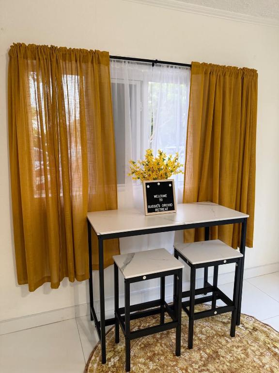 a table with two chairs in front of a window at Your Blooming Getaway in Nassau
