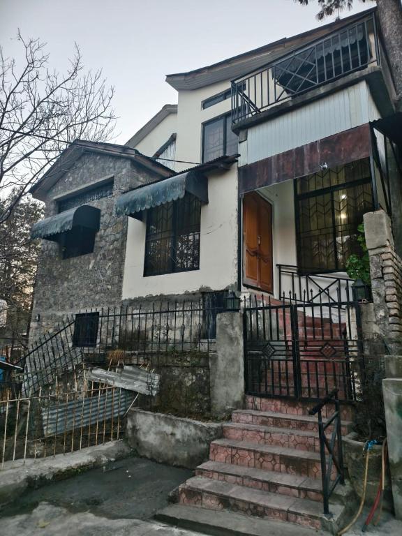 a house with a staircase in front of it at Naqvi House in Murree
