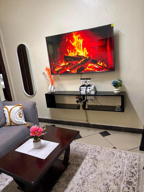 a living room with a fire pit on the wall at Terry's 2br sunsweet resort shanzu,mombasa in Mombasa
