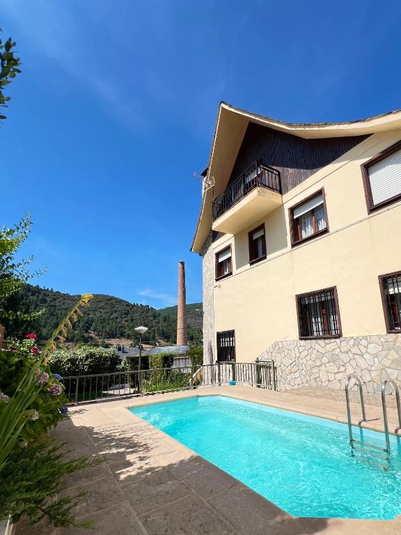 ein Haus mit Swimmingpool neben einem Gebäude in der Unterkunft La Almendrina Casa Rural in Villafranca del Bierzo