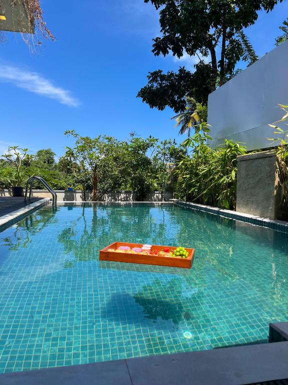 a swimming pool with a bench in the water at Ruchi Villa in Wadduwa