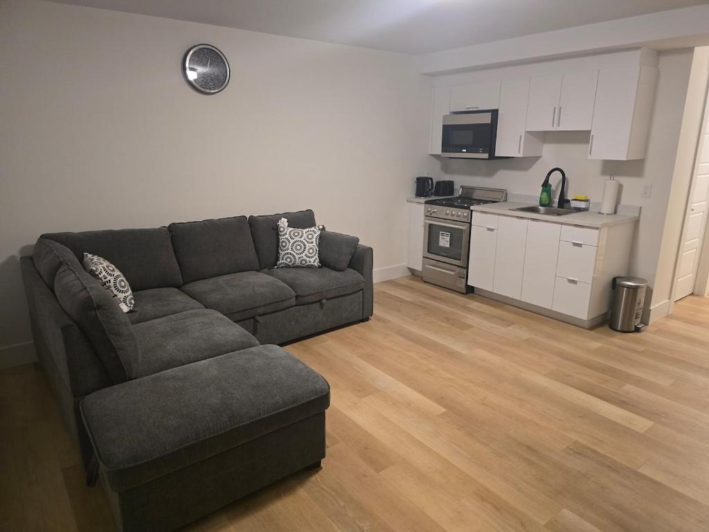 a living room with a couch and a kitchen at TeeBams's Comfy Home in Riverview