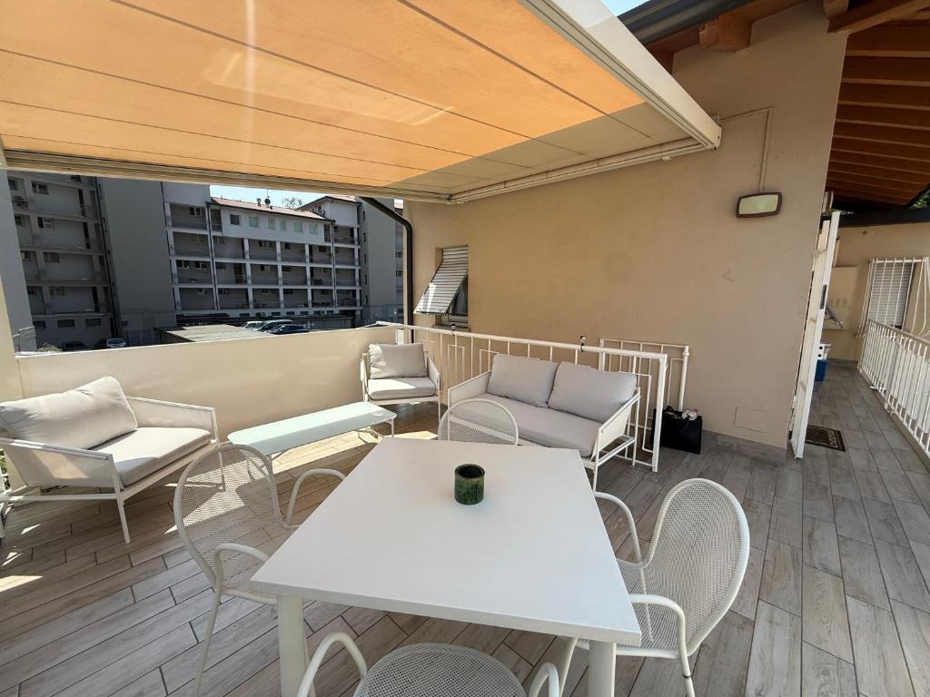 a patio with white tables and chairs on a balcony at Casa Miki in Sarnico