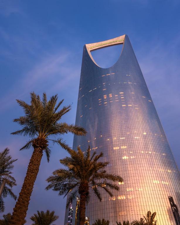 a tall building with palm trees in front of it at Four Seasons Hotel Riyadh in Riyadh