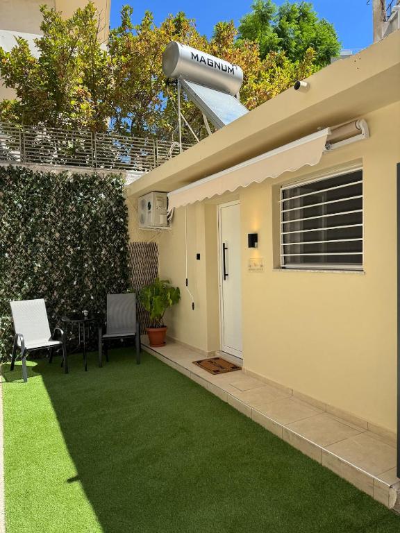 a backyard with green grass and a house at Modern studio in Athens