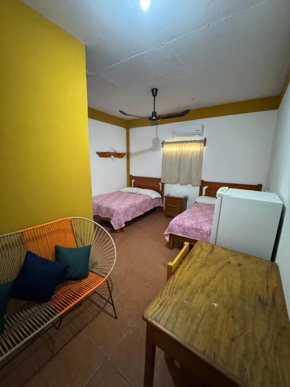 a room with two beds and a table and chairs at Casa Santa Elena in Brisas de Zicatela