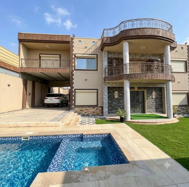 a house with a swimming pool in front of it at فيلا في كينج مريوط in Alexandria